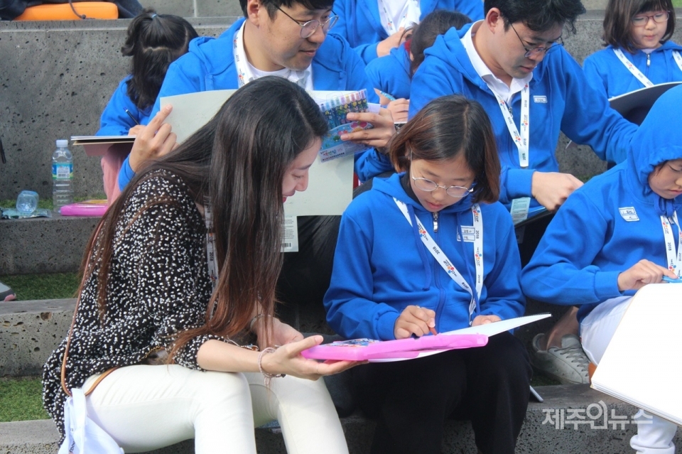 ▲ 사생대회에 참가한 여학생과 CJ대한통운 임직원 자원봉사자가 함께 사생대회에 집중하고 있는 모습.