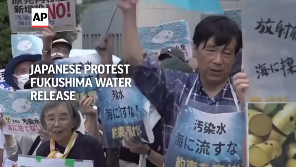 25일 도쿄의 일본 총리실 앞에서 시위대가 후쿠시마 원전에서 처리된 방사능 오염수가 방출되는 것에 대한 시위를 벌이고 있다. : AP 영상 캡처