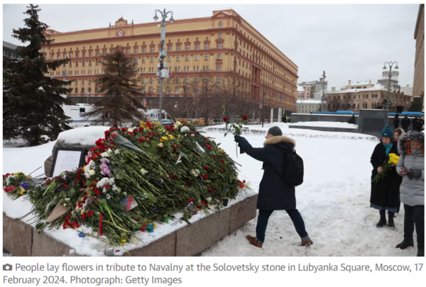 17일 모스크바 루뱐카 광장의 솔로베츠키 돌에 한 추모객이 나발니를 기리기 위해 꽃을 올리고 있다. Guardian 기사 본문 캡처
